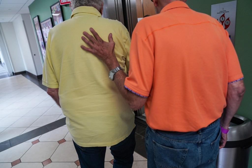 Jay Reinstein, right, who suffers from Alzheimer's, places his hand on the back of his father Max Reinstein before receiving a PET scan at MedStar Georgetown University Hospital in Washington, DC on June 20, 2023.