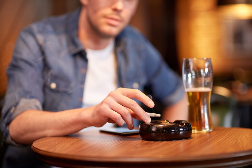 Man smoking with a beer in a bar