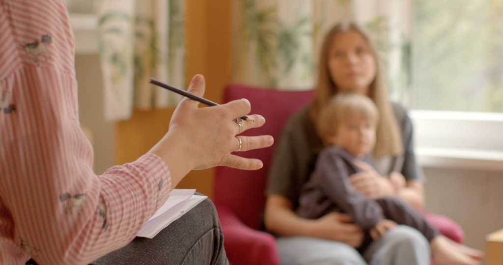 An international team of researchers says that variants of the DDX53 gene may be to blame for the male predominance of autism. Here, a specialist talks to a woman carrying a young boy.