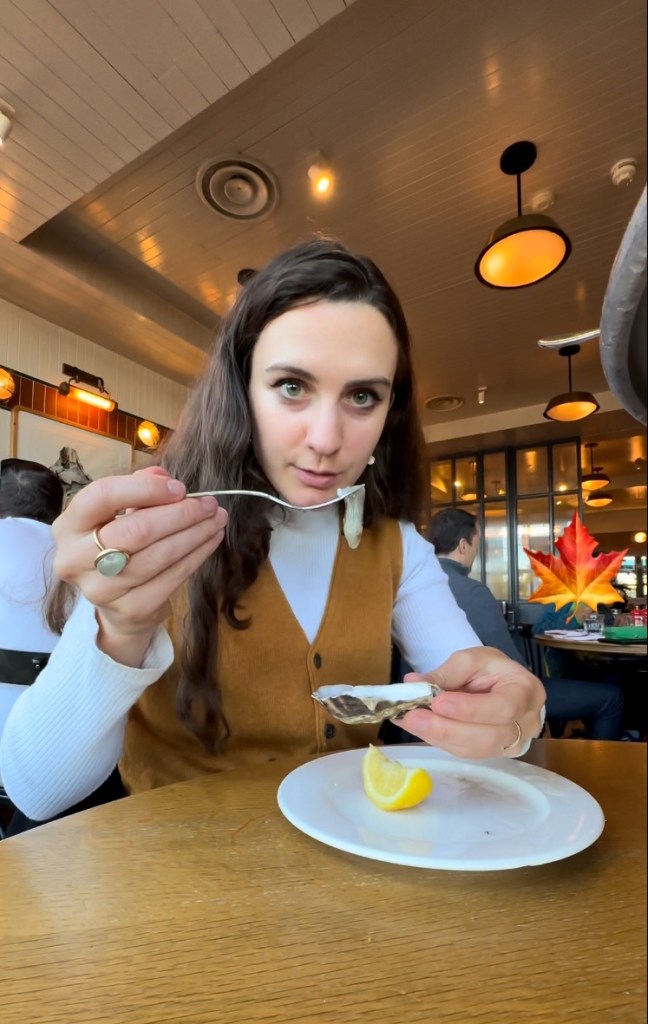 Georgiana eats an oyster.